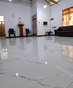 a living room with a white floor and a couch at Lagora Villa in Moraketiara