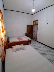 a room with two beds in a room with a window at Lagora Villa in Moraketiara
