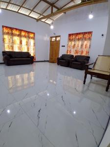 a living room with white marble floors and couches at Lagora Villa in Moraketiara