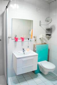 W łazience znajduje się umywalka, toaleta i lustro. w obiekcie Hotel An der Sauer w mieście Minden