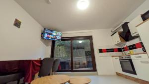 a kitchen with a table and a television in a room at Marco City Apartment Werne - Terrasse, Küche & WLAN in Werne an der Lippe