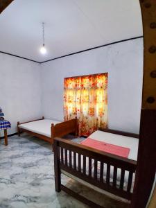 a room with two beds and a painting on the wall at Lagora Villa in Moraketiara +2 photos