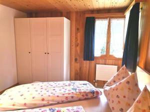 a bedroom with a bed and a cabinet and windows at Apartment Gemütliche FeWo by Interhome in Innertkirchen