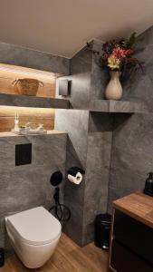 a bathroom with a toilet and a vase with flowers at Deluxe 707 in Borovets