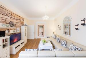 ein Wohnzimmer mit einem weißen Sofa und einem TV in der Unterkunft Ferienwohnung am Kaiserhof in Quedlinburg