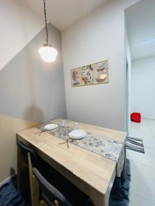 a dining room table with two white plates on it at Majestic Residence Klcc by Luxury in Kuala Lumpur