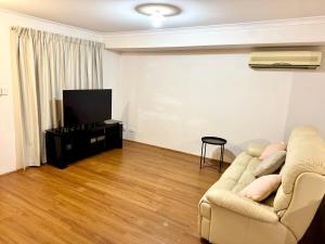 a living room with a couch and a flat screen tv at Affordable accommodation near Perth CBD in Perth