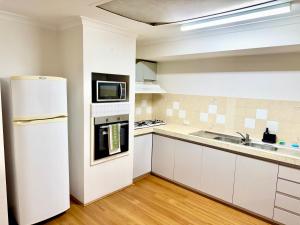 a kitchen with a white refrigerator and a sink at Affordable accommodation near Perth CBD in Perth