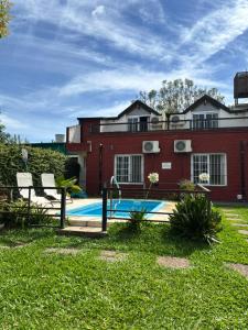 een zwembad voor een rood gebouw bij Complejo El Guri in Colón