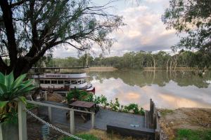 a boat is docked on a river at The Riverview BnB in Mildura