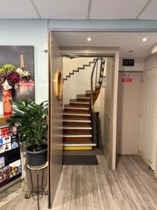 un couloir avec un escalier dans un immeuble dans l'établissement Hôtel Jarry Confort, à Paris