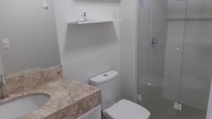 a bathroom with a sink and a toilet and a shower at Apto 3 quartos Centro Torres RS in Torres +27 photos