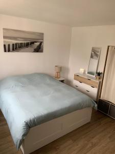 a white bedroom with a bed and a mirror at Appartement Carnac, Centre bourg - 2 pieces in Carnac +1 photo