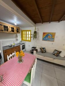 a kitchen and living room with a table and a couch at Casa no Norte da Ilha in Florianópolis