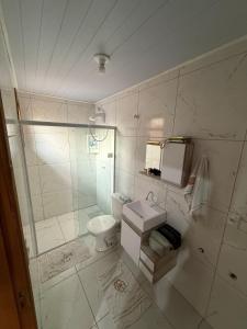 a white bathroom with a sink and a toilet at Casa no Norte da Ilha in Florianópolis