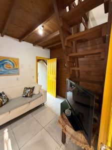 a living room with a couch and a tv at Casa no Norte da Ilha in Florianópolis