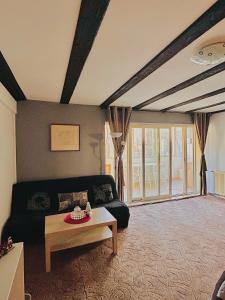 ein Wohnzimmer mit Sofa und Tisch in der Unterkunft Casa Oriana in Predeal