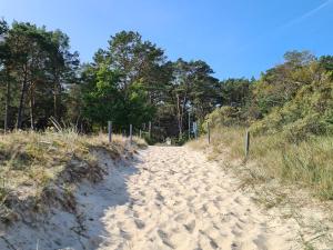 a dirt road leading up to a beach at Strandhaus Rügen 243 in Baabe