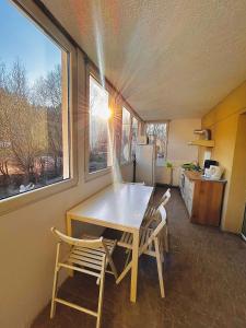 einen Tisch und Stühle in einer Küche mit Fenster in der Unterkunft Casa Oriana in Predeal