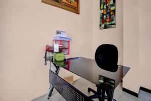 a glass desk in a room with a chair at OYO 94899 Homestay Syariah Near UPN in Medokanayu