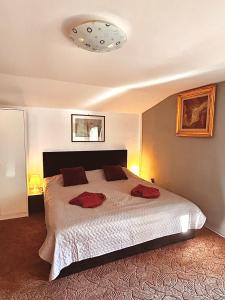 ein Schlafzimmer mit einem Bett mit zwei roten Kissen darauf in der Unterkunft Casa Oriana in Predeal