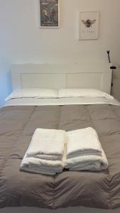 twee handdoeken liggen bovenop een bed bij Alla Casetta in Cagliari