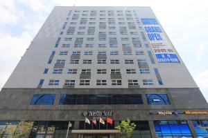 wysoki biały budynek z napisem w obiekcie Intercity Seoul Hotel w Seulu