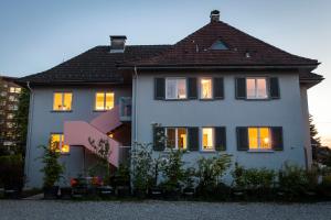 a white house with its lights on at 4Stubenhaus in Dornbirn