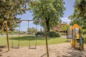 une aire de jeux dans un parc avec une balançoire dans l'établissement Agriturismo Villa Beatrice, à Mondavio