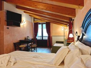 a bedroom with a bed and a desk in a room at Hotel L' Aiglon in Champoluc