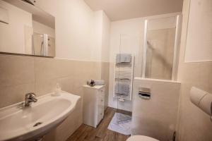 een witte badkamer met een wastafel en een douche bij Oberhof Apt Lärchenwald in Vallarga +17 foto's