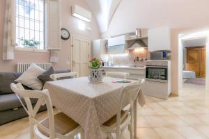 een keuken en een woonkamer met een tafel en stoelen bij A Casa Di Francesca in Lecce