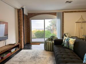een woonkamer met een bank en een groot raam bij Oceans 21 Caves Beach in Caves Beach