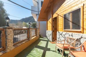 een veranda van een huis met 2 stoelen en een raam bij El mágico Refugio de las Vegas in Valsequillo