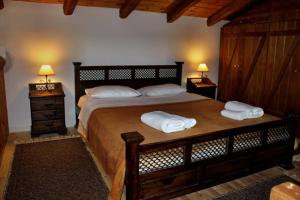 una camera da letto con un grande letto con due asciugamani di Petrina Theohari a Lekhoúrion