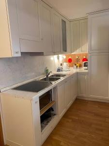 una cucina con mobili bianchi e un lavandino di Appartamento Le Cigamole a Valfurva