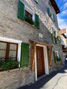 un edificio con persiane verdi e una porta di Appartamento Le Cigamole a Valfurva