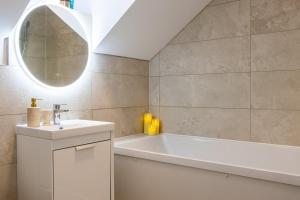 a bathroom with a tub and a sink and a mirror at GuestReady Cozy Dublin Hideaway in Dublin