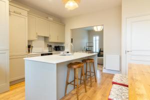 a kitchen with a white counter top and wooden stools at GuestReady Cozy Dublin Hideaway in Dublin