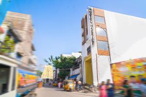 een straat met gebouwen en mensen die over straat lopen bij Hotel Harriet in Rāmeswaram