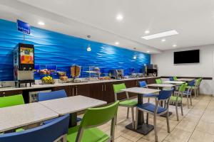 a restaurant with tables and chairs and a blue wall at Best Western Starke in Starke