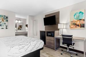 a bedroom with a bed and a desk and a chair at Best Western Starke in Starke