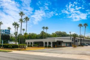 a building with palm trees in a parking lot at Best Western Starke in Starke