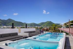 una vasca idromassaggio su un balcone con vista sulle montagne sullo sfondo di Commodore Suites, SureStay Collection by Best Western a Simpson Bay