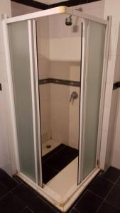 a shower with a glass door in a bathroom at Studio55 in Lomé