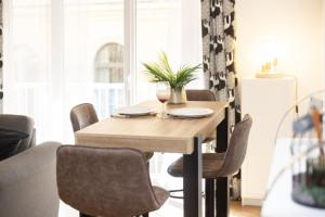 a dining room table and chairs with wine glasses and a plant at Sweet Evasion - Wifi - Host Provence in Toulon