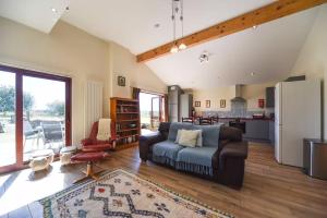 a living room with a couch and a kitchen at Amber Cabin in Ashover