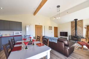 a kitchen and living room with a table and a couch at Amber Cabin in Ashover