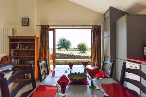 a dining room with a table and a large window at Amber Cabin in Ashover