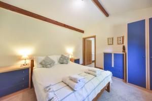 a bedroom with a bed with towels on it at Amber Cabin in Ashover +7 photos
